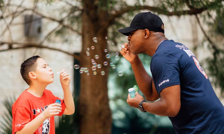 Good Grief Camp Boy and Mentor blowing bubbles